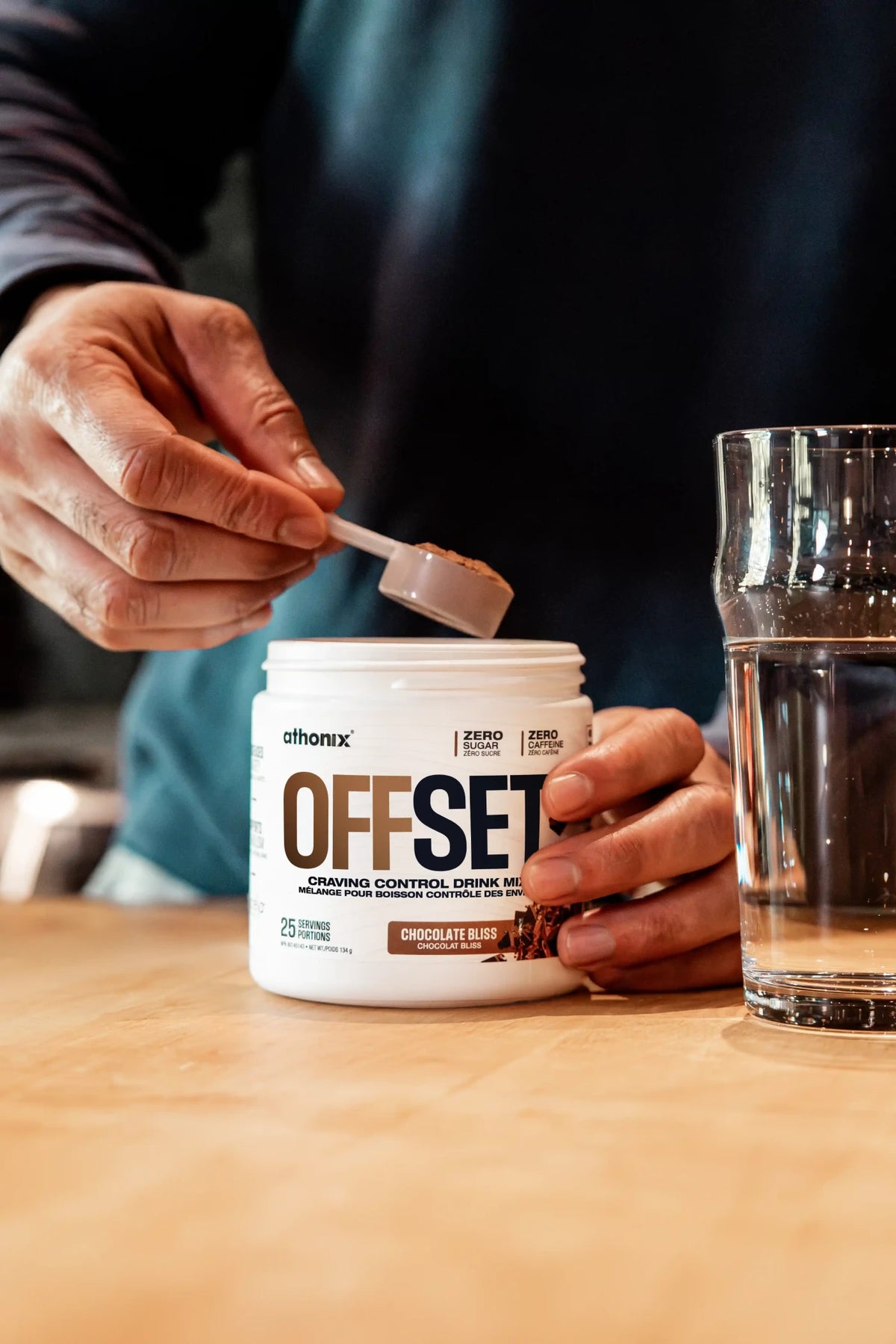 Scoop of Athonix OFFSET Chocolate Bliss powder being lifted from the bottle