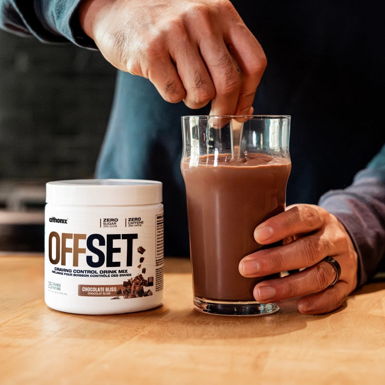 Athonix OFFSET Chocolate Bliss powder being stirred into a glass of water
